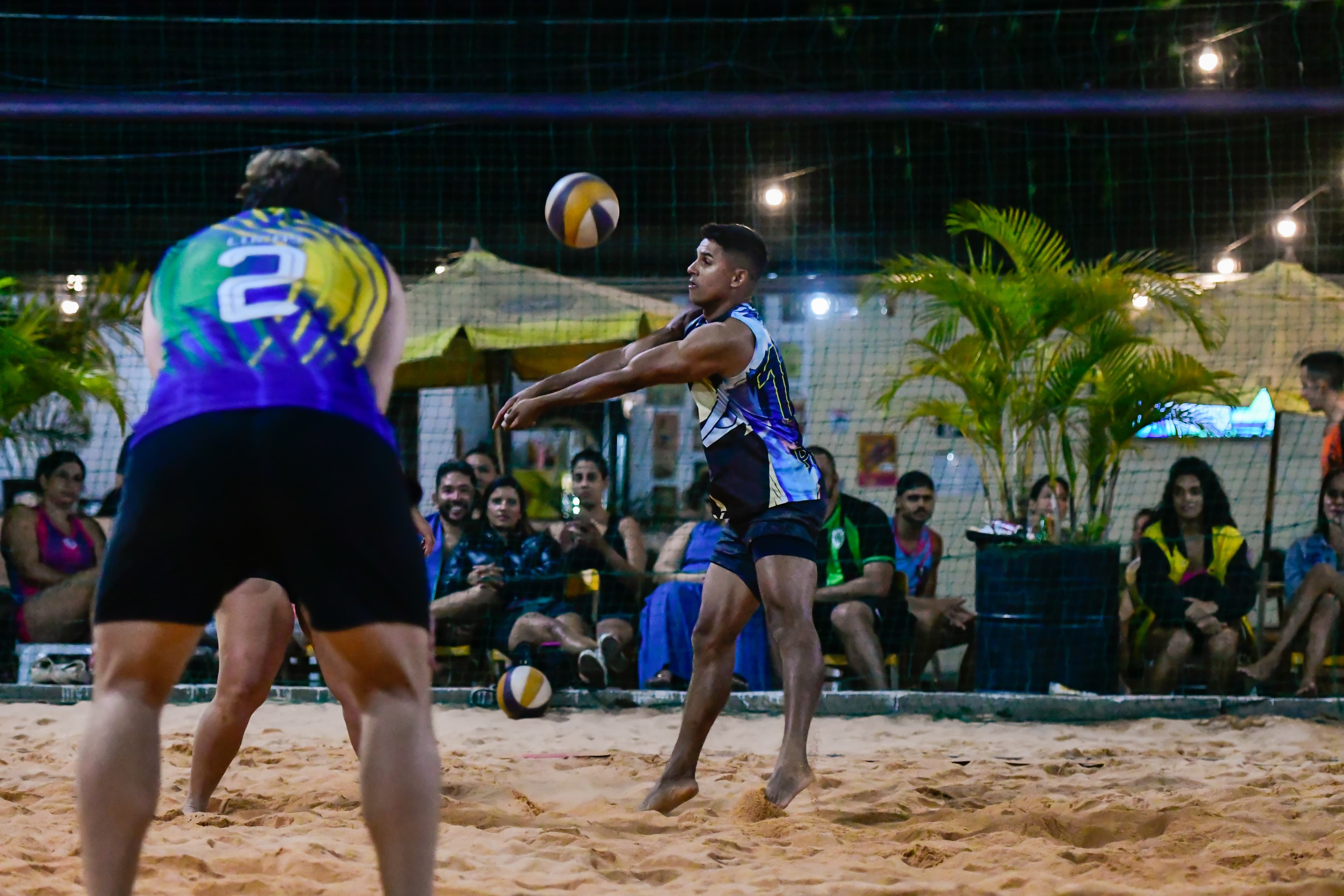 Atleta recebendo a bola durante partida de vôlei de areia